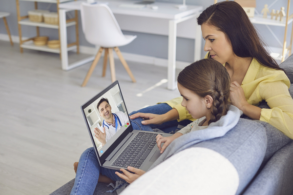 Mother and daughter looking at a laptop together.