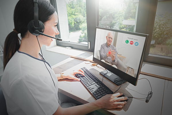 Woman wearing a headset while looking at her computer screen.