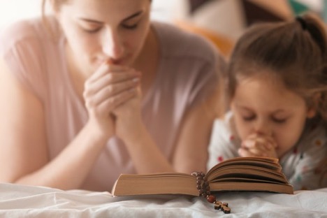 mother praying with her child