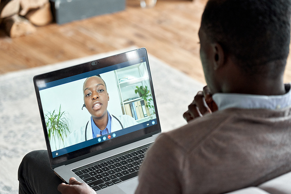 Man on laptop with doctor during telehealth visit