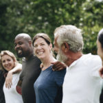 People standing shoulder to shoulder smiling